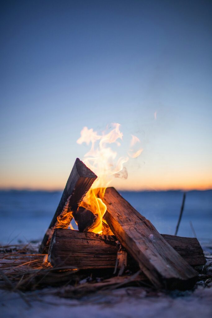 Wu00e4rmendes Feuer im Schnee zur blauen Stunde, Sinnbild fu00fcr die Raunu00e4chte