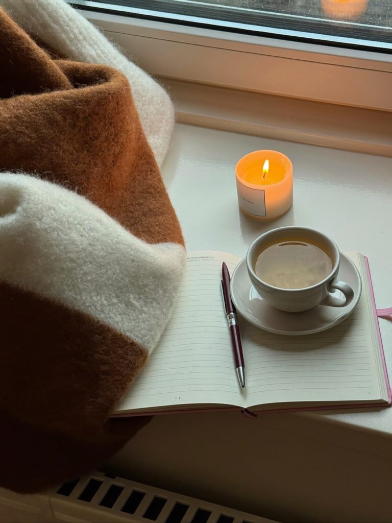Teetasse, Journal und Kerze am Fenster, ein Moment nur fu00fcr dich